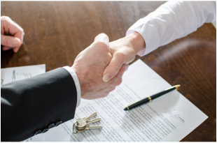 Partijen schudden elkaar de hand boven een ondertekend huurcontract